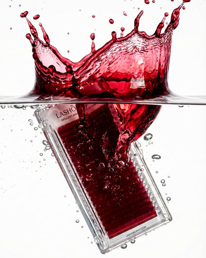 Deep red VINOIRE lash extensions by LASHÒSOPHY submerged in water with dramatic red splash — matte Korean fiber colored lashes product photo.